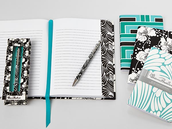 Textile patterns printed on special paper wraps these stationery items.  Ball point pen in deluxe box; Casebound journal with bookmark, set of 3 journals with flexible covers.